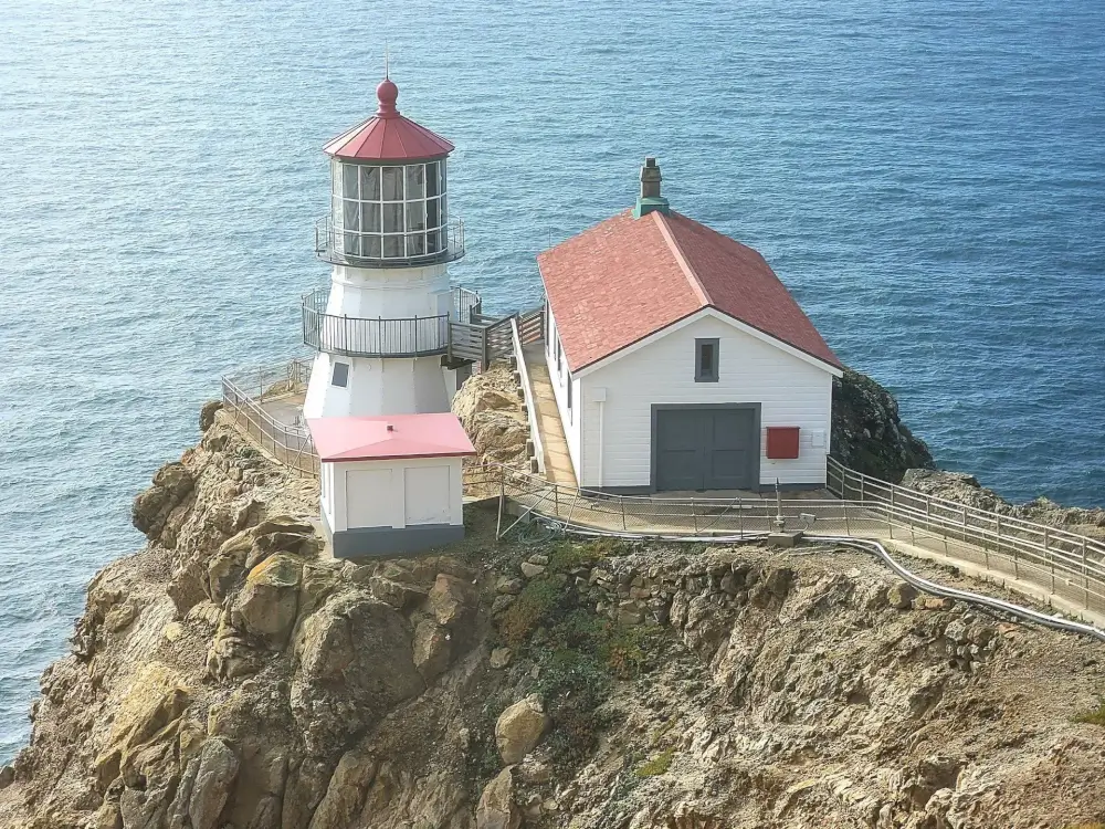 Looking down toward Point Reyes Lighthouse, CA. Keepers house next door. All perched on a rocky point above ocean.