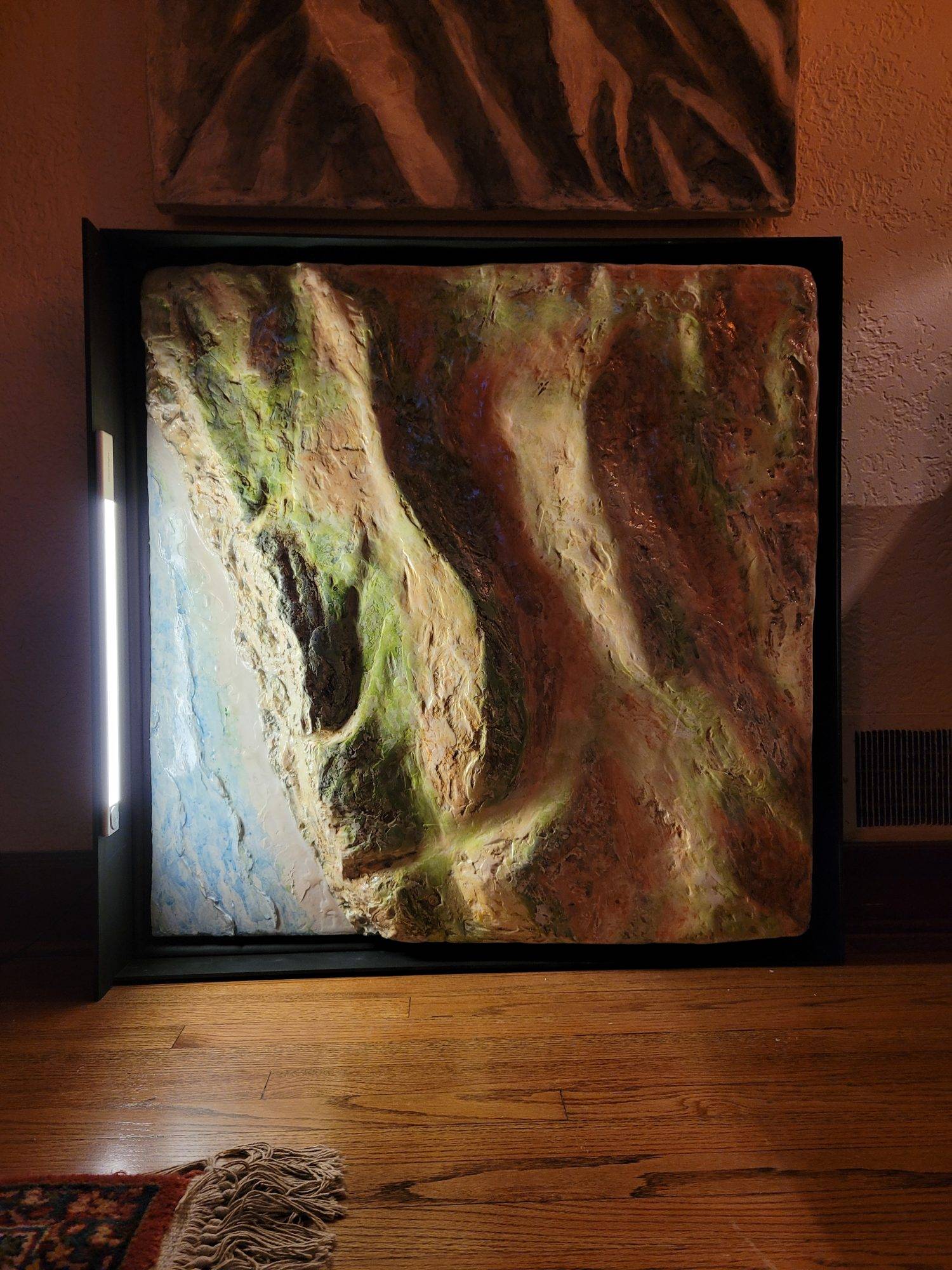 3D sculpture of land at Jalama Beach, California painted in watercolor, equipped with motion sensor light on the left side pretending to be the setting sun.