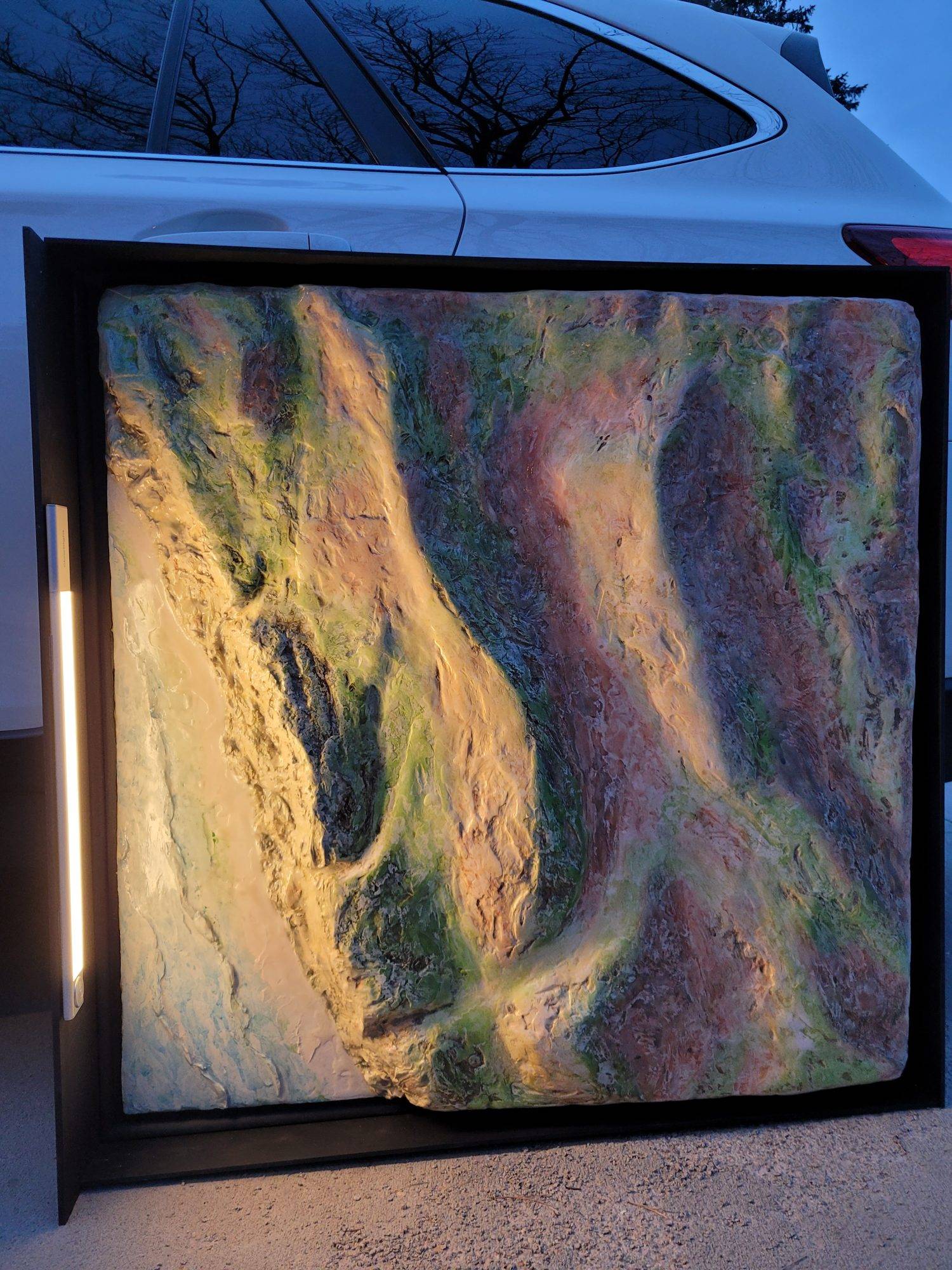 3D sculpture of land at Jalama Beach, California painted in watercolor, equipped with motion sensor light on the left side pretending to be the setting sun.