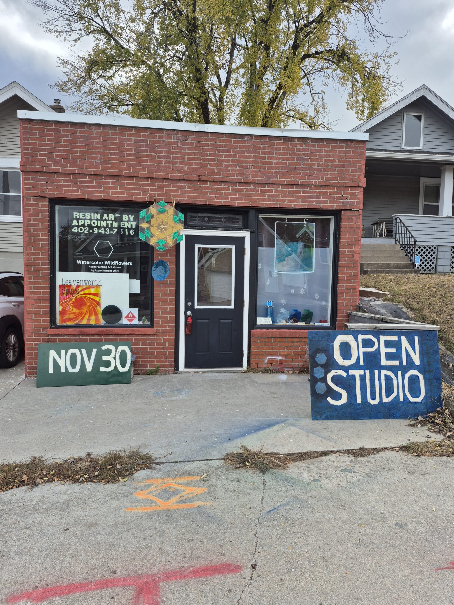 brick building with window and door and resin art hanging. This is the entrance to my studio in Omaha at 5069 Leavenworth Street