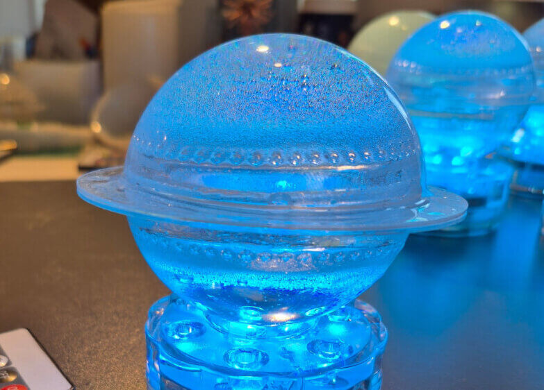 globe with disk looks like planet with rings is lit by LED puck light underneath